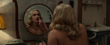 Movie still from “Mrs. Harris Goes to Paris” (2022), directed by Anthony Fabian – A woman putting lipstick on in front of a mirror; Close Up shot, Over the shoulder angle