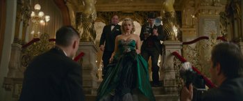 Movie still from “Mrs. Harris Goes to Paris” (2022), directed by Anthony Fabian – A woman in a green dress walking down a staircase; Wide shot, Low angle
