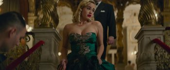 Movie still from “Mrs. Harris Goes to Paris” (2022), directed by Anthony Fabian – A woman in a green dress is standing next to a man in a black suit; Medium shot, Low angle