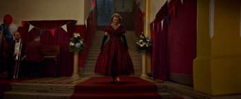Movie still from “Mrs. Harris Goes to Paris” (2022), directed by Anthony Fabian – A woman in a red dress standing on a red carpet; Wide shot, Low angle