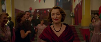 Movie still from “Mrs. Harris Goes to Paris” (2022), directed by Anthony Fabian – An older woman wearing a red dress and a black necklace; Medium shot, Low angle