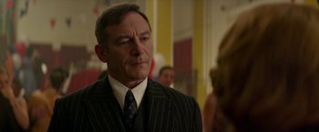 Movie still from “Mrs. Harris Goes to Paris” (2022), directed by Anthony Fabian – A man in a suit and a tie; Close Up shot, Over the shoulder angle