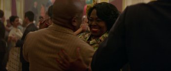 Movie still from “Mrs. Harris Goes to Paris” (2022), directed by Anthony Fabian – A woman smiles as she hugs a man; Close Up shot, Over the shoulder angle