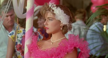 Movie still from “Muriel's Wedding” (1994), directed by P.J. Hogan – A woman in a pink dress with a white flower in her hair; Close Up shot, Over the shoulder angle