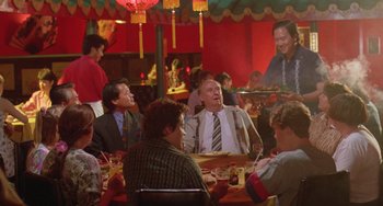 Movie still from “Muriel's Wedding” (1994), directed by P.J. Hogan – A group of people sitting at a table in a restaurant; Medium shot, Over the shoulder angle