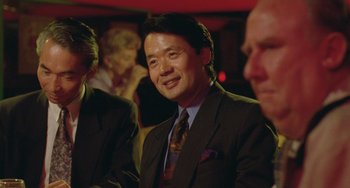 Movie still from “Muriel's Wedding” (1994), directed by P.J. Hogan – A person wearing a suit and tie; Close Up shot, Over the shoulder angle