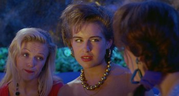 Movie still from “Muriel's Wedding” (1994), directed by P.J. Hogan – A woman wearing a gold necklace and earrings; Close Up shot, Over the shoulder angle