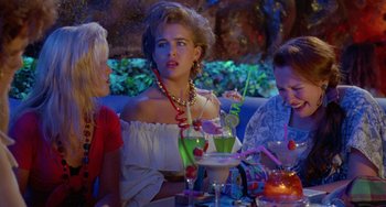 Movie still from “Muriel's Wedding” (1994), directed by P.J. Hogan – A woman sitting at a table in front of two other people; Medium shot, Over the shoulder angle