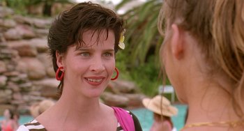 Movie still from “Muriel's Wedding” (1994), directed by P.J. Hogan – A woman wearing a pink shirt and red earrings talking to another woman; Close Up shot, Over the shoulder angle