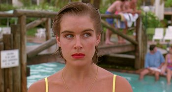 Movie still from “Muriel's Wedding” (1994), directed by P.J. Hogan – A person wearing a yellow shirt near a body of water; Close Up shot, Over the shoulder angle