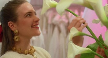 Movie still from “Muriel's Wedding” (1994), directed by P.J. Hogan – A woman in a white dress is holding a flower; Close Up shot, Low angle