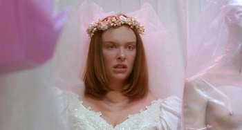 Movie still from “Muriel's Wedding” (1994), directed by P.J. Hogan – A woman in a wedding dress with a flower crown; Close Up shot, Over the shoulder angle