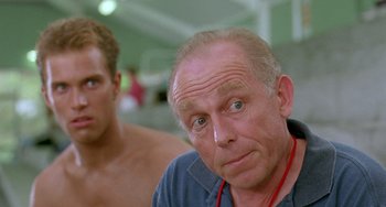 Movie still from “Muriel's Wedding” (1994), directed by P.J. Hogan – An older man and a younger man in a room; Close Up shot, Low angle