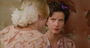 Movie still from “Muriel's Wedding” (1994), directed by P.J. Hogan – A woman looking into a mirror while standing next to another woman; Close Up shot, Over the shoulder angle