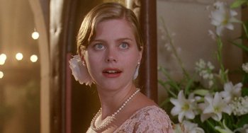 Movie still from “Muriel's Wedding” (1994), directed by P.J. Hogan – A young woman wearing a pink dress and pearls; Close Up shot, Over the shoulder angle