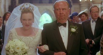 Movie still from “Muriel's Wedding” (1994), directed by P.J. Hogan – A man and a woman in wedding attire in front of a crowd; Close Up shot, Low angle