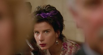 Movie still from “Muriel's Wedding” (1994), directed by P.J. Hogan – A person with a purple bow in her hair; Close Up shot, Over the shoulder angle