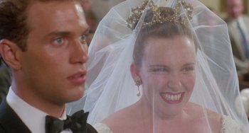 Movie still from “Muriel's Wedding” (1994), directed by P.J. Hogan – A woman wearing a tiara and veil next to a man wearing a tuxedo; Close Up shot, Over the shoulder angle