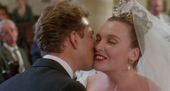 Movie still from “Muriel's Wedding” (1994), directed by P.J. Hogan – A man and a woman kissing; Close Up shot, Over the shoulder angle
