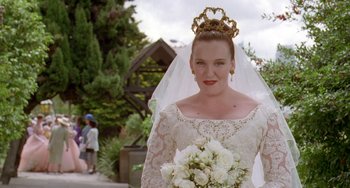 Movie still from “Muriel's Wedding” (1994), directed by P.J. Hogan – A woman in a wedding dress holding a bouquet of flowers; Close Up shot, Low angle