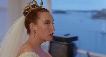 Movie still from “Muriel's Wedding” (1994), directed by P.J. Hogan – A woman wearing a tiara and a white dress; Close Up shot, Over the shoulder angle