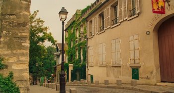 Movie still from “Midnight in Paris” (2011), directed by Woody Allen – A lamp post on the side of the street in front of a building; Extreme Wide shot, Low angle