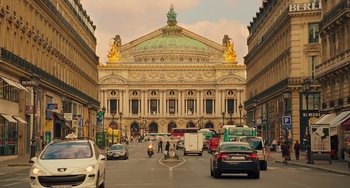 Movie still from “Midnight in Paris” (2011), directed by Woody Allen – A busy street with cars , buses , and motorcycles on it; Extreme Wide shot, Low angle