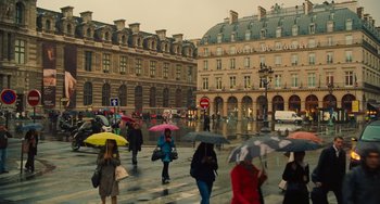 Movie still from “Midnight in Paris” (2011), directed by Woody Allen – A group of people walking on the sidewalk with umbrellas; Extreme Wide shot, High angle