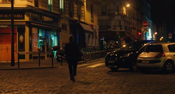 Movie still from “Midnight in Paris” (2011), directed by Woody Allen – A person walking down a street at night; Wide shot, High angle