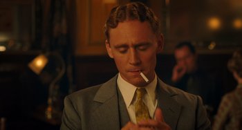 Movie still from “Midnight in Paris” (2011), directed by Woody Allen – A man in a suit and tie smoking a cigarette; Close Up shot, Over the shoulder angle