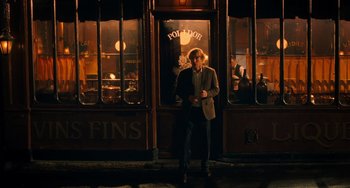 Movie still from “Midnight in Paris” (2011), directed by Woody Allen – A man standing in front of a store at night; Wide shot, Over the shoulder angle