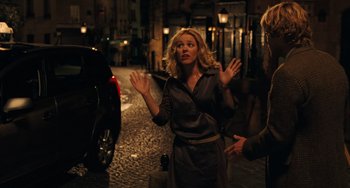 Movie still from “Midnight in Paris” (2011), directed by Woody Allen – A woman standing next to a car on a street; Medium shot, Over the shoulder angle