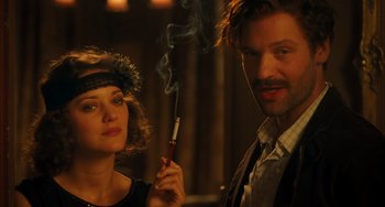 Movie still from “Midnight in Paris” (2011), directed by Woody Allen – A man and a woman holding a cigarette in a dark room; Close Up shot, Over the shoulder angle