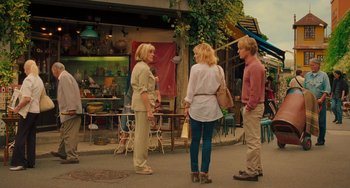 Movie still from “Midnight in Paris” (2011), directed by Woody Allen – A group of people standing on the side of the street; Wide shot, Over the shoulder angle