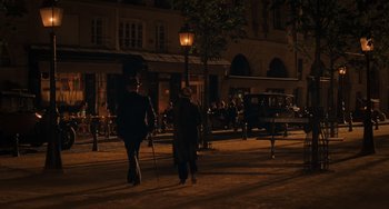 Movie still from “Midnight in Paris” (2011), directed by Woody Allen – Two people walking down a street at night; Wide shot, High angle