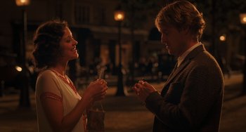 Movie still from “Midnight in Paris” (2011), directed by Woody Allen – A man and a woman standing next to each other on a street; Medium shot, Over the shoulder angle