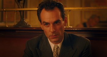 Movie still from “Midnight in Paris” (2011), directed by Woody Allen – A person wearing a suit and tie; Close Up shot, High angle