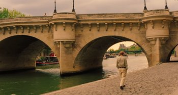 Movie still from “Midnight in Paris” (2011), directed by Woody Allen – A man walking down the side of a bridge; Wide shot, Over the shoulder angle