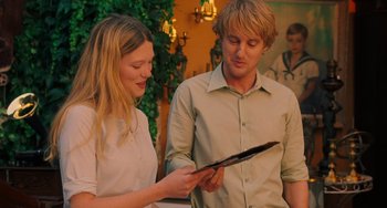Movie still from “Midnight in Paris” (2011), directed by Woody Allen – A man and a woman looking at a tablet; Medium shot, Over the shoulder angle