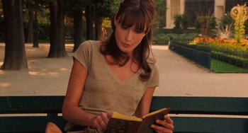 Movie still from “Midnight in Paris” (2011), directed by Woody Allen – A woman sitting on top of a park bench reading a book; Close Up shot, Over the shoulder angle