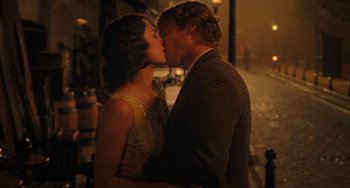 Movie still from “Midnight in Paris” (2011), directed by Woody Allen – A man and a woman kissing each other in the rain; Medium shot, High angle