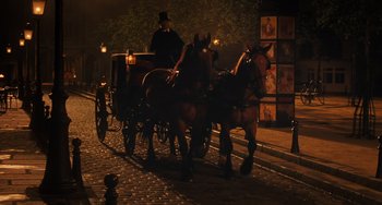 Movie still from “Midnight in Paris” (2011), directed by Woody Allen – A man riding in a carriage pulled by two horses at night; Wide shot, Low angle