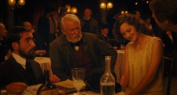 Movie still from “Midnight in Paris” (2011), directed by Woody Allen – An older man sitting at a table with a woman; Medium shot, Over the shoulder angle