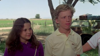 Movie still from “Vacation” (1983), directed by Harold Ramis – A boy and a girl standing next to each other in a field; Close Up shot, Low angle