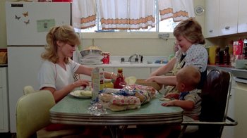 Movie still from “Vacation” (1983), directed by Harold Ramis – Three people sitting at a table eating sandwiches; Medium shot, High angle