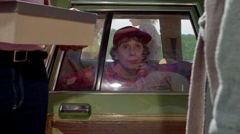 Movie still from “Vacation” (1983), directed by Harold Ramis – A woman sitting in the passenger seat of a green car; Medium shot, Over the shoulder angle