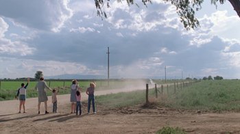 Movie still from “Vacation” (1983), directed by Harold Ramis – A group of people standing on the side of a dirt road; Extreme Wide shot, Low angle