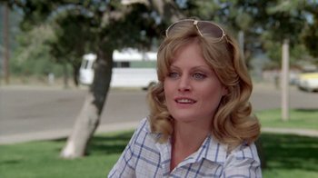 Movie still from “Vacation” (1983), directed by Harold Ramis – A person wearing sunglasses and a plaid shirt; Close Up shot, Over the shoulder angle
