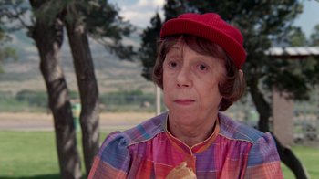 Movie still from “Vacation” (1983), directed by Harold Ramis – An older woman wearing a red hat eating a hot dog; Close Up shot, Over the shoulder angle