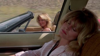 Movie still from “Vacation” (1983), directed by Harold Ramis – Two women in the back seat of a car; Medium shot, Over the shoulder angle